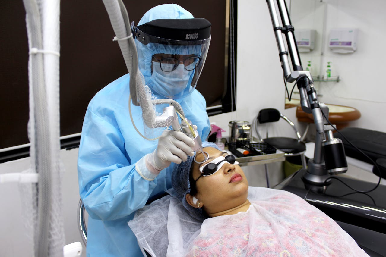 A medical practitioner performs laser treatment on a woman for skin care.